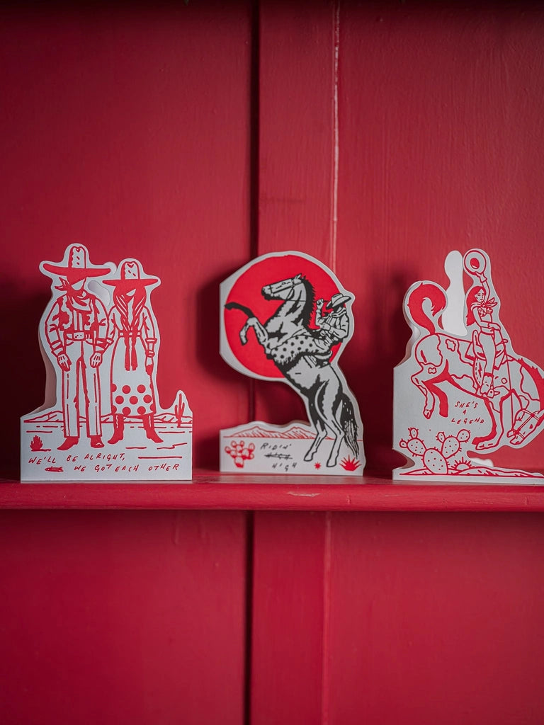 Archivist cut-out cards standing on a red shelf