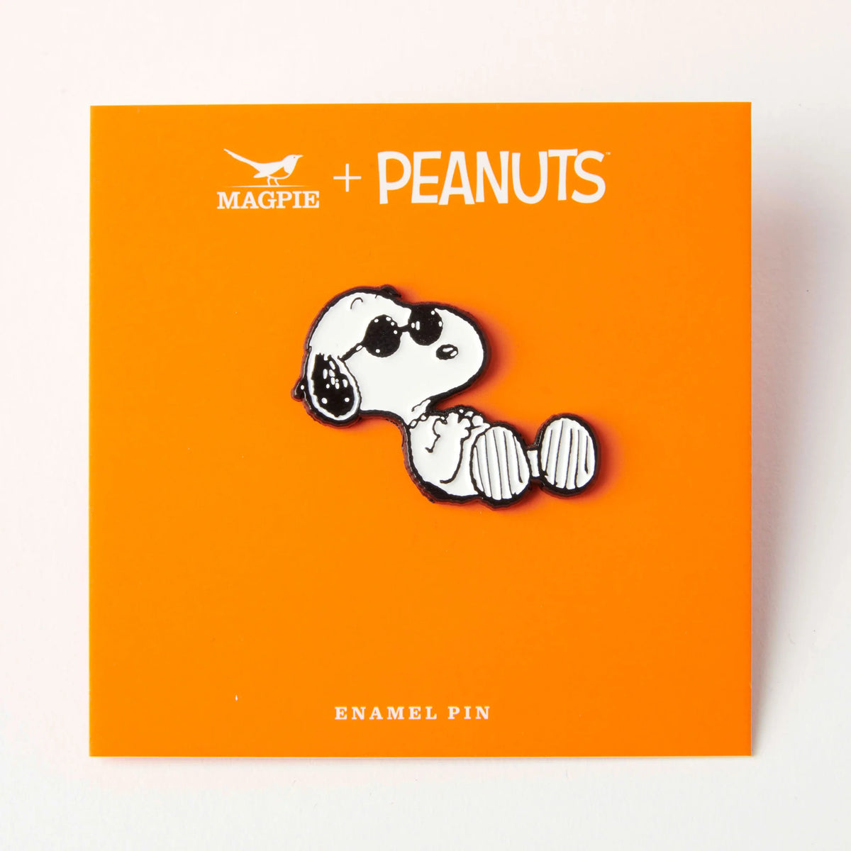 Snoopy slacker pin on its orange Magpie x Peanuts backing card
