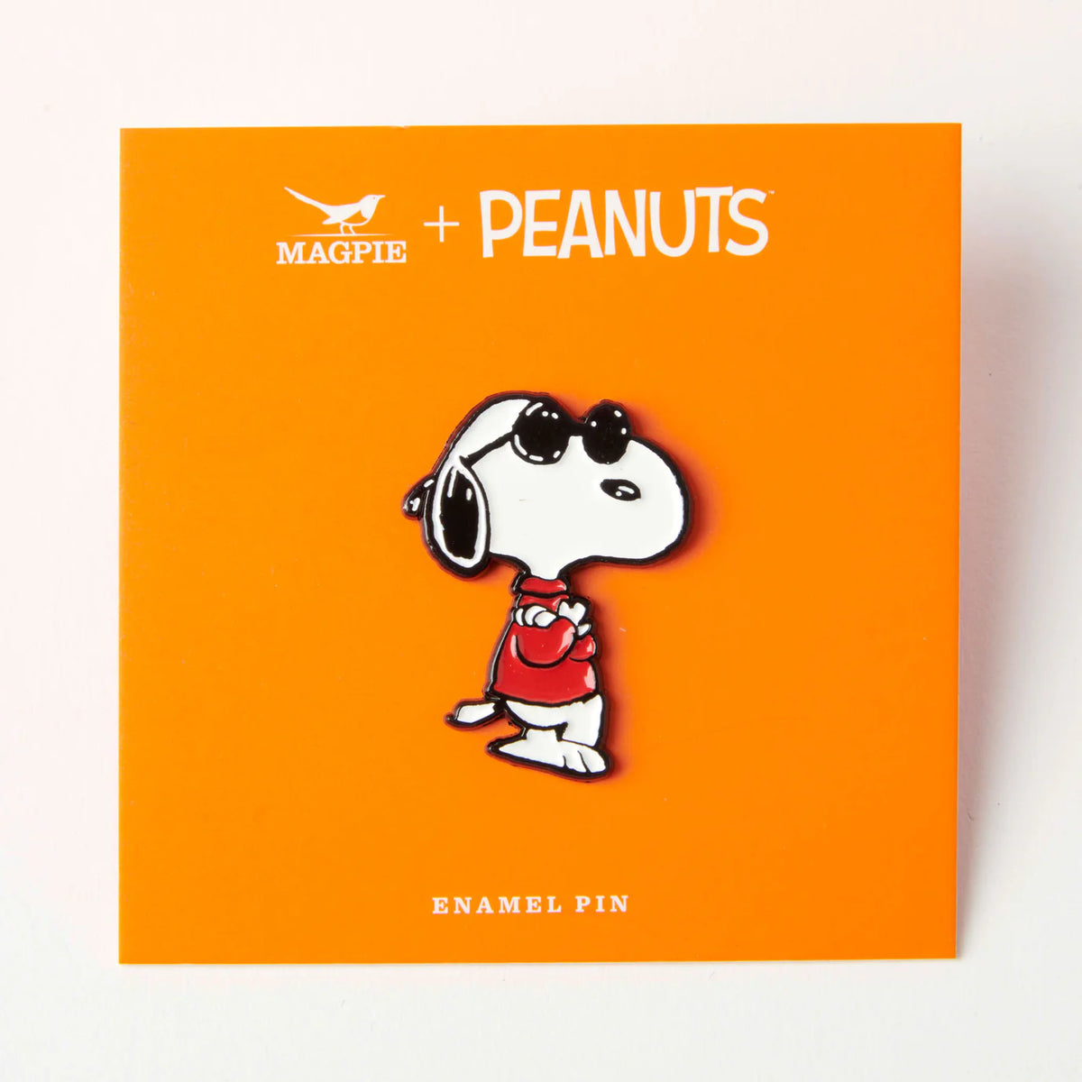 Joe Cool pin on its orange Magpie x Peanuts card
