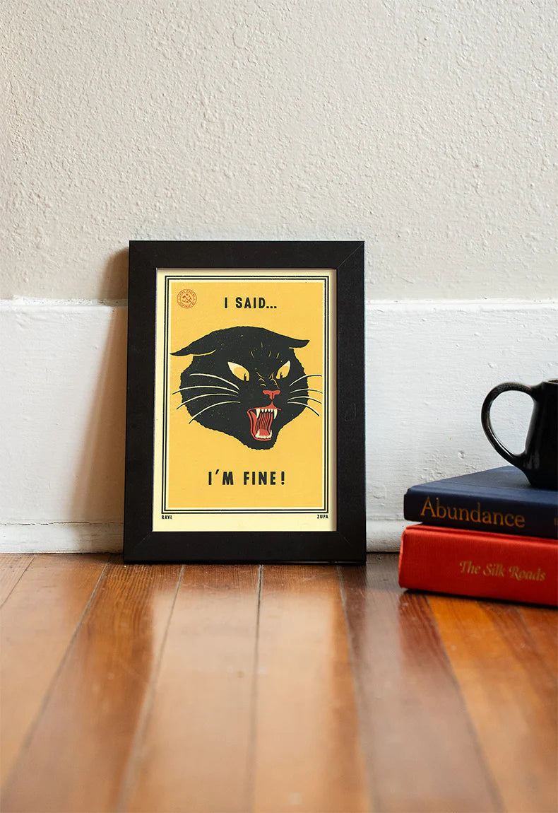 I Said I'm Fine print in a black frame on a wooden floor