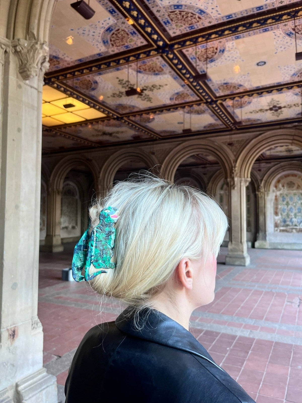 T-Rex claw clip in blonde hair under an arcade