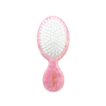 Pink hairbrush showing its white bristles