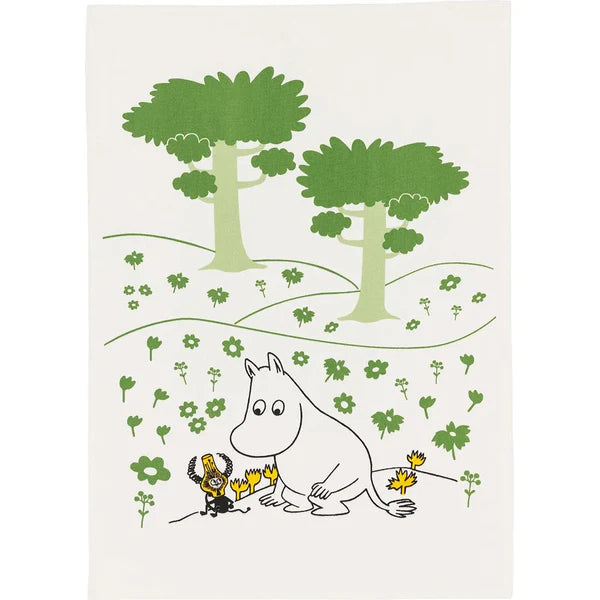 White tea towel with Moomintroll lying in green clover under two trees