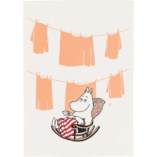 White tea towel with Moominmamma in a rocking chair below orange washing on a line