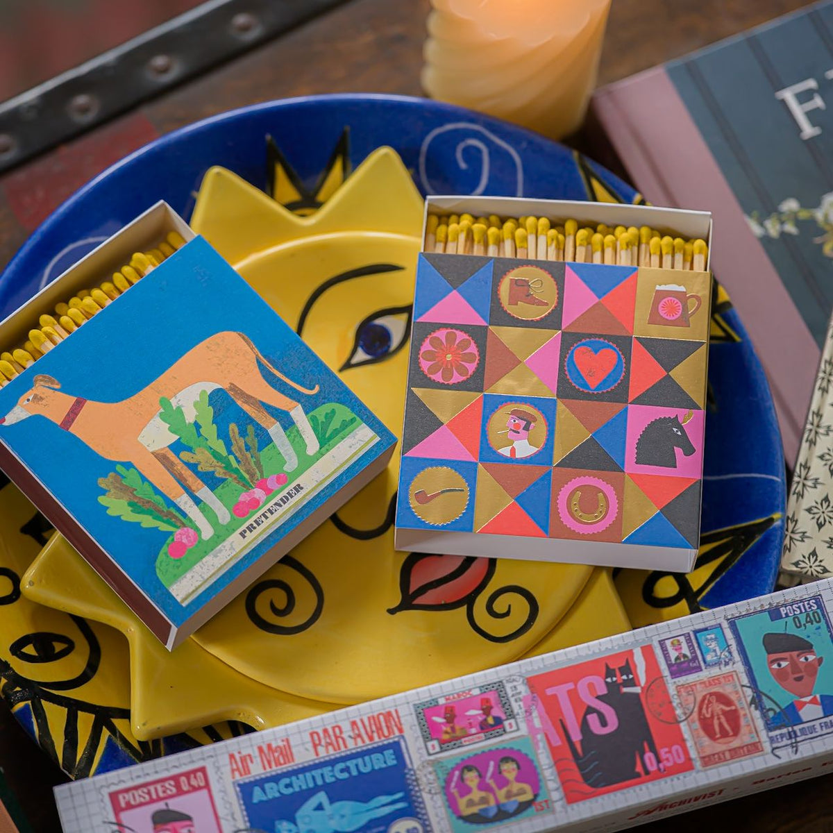 Gentleman matchbox and whippet matchbox on a yellow sun plate