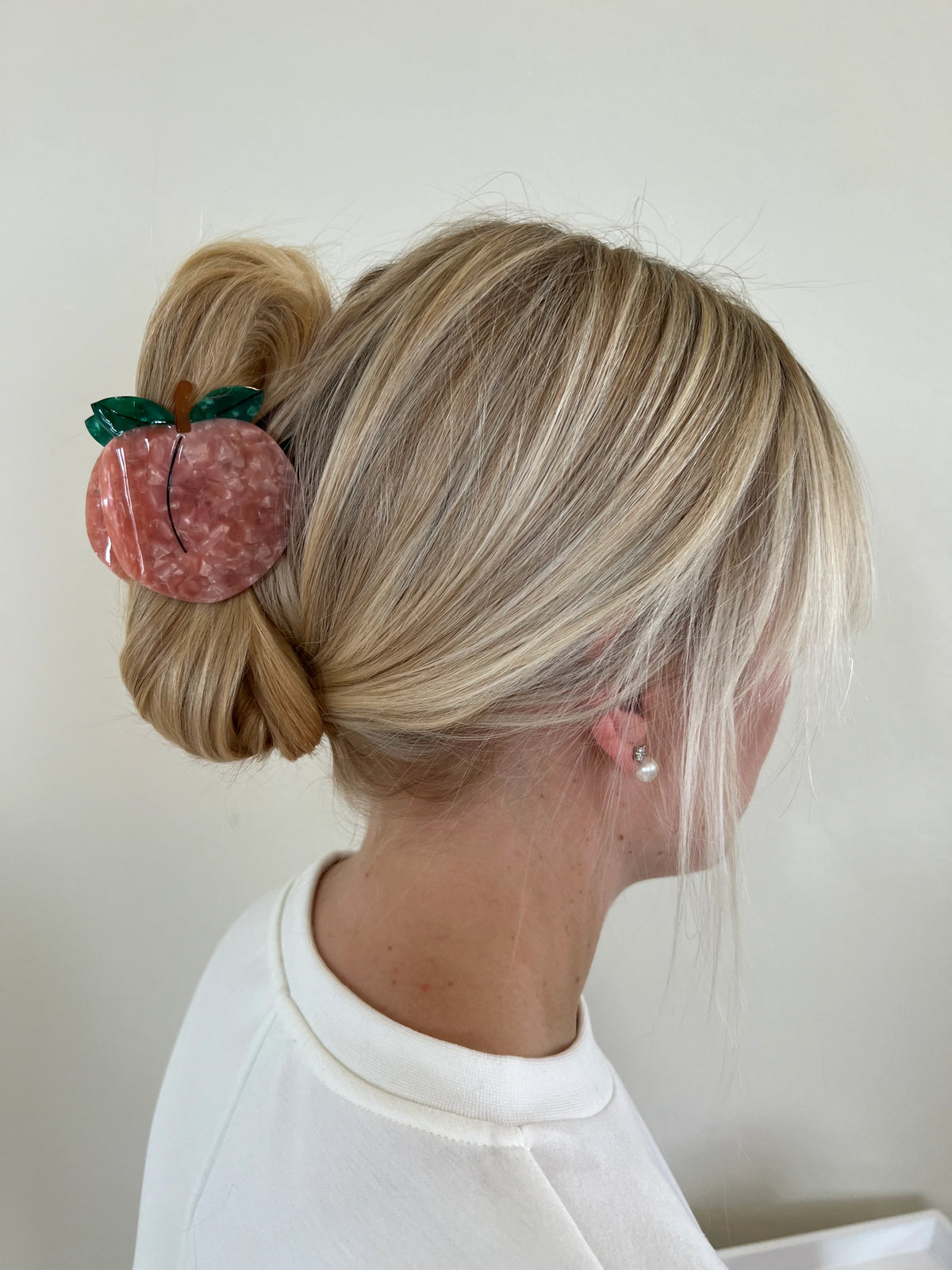 Peach claw clip holding up blonde hair
