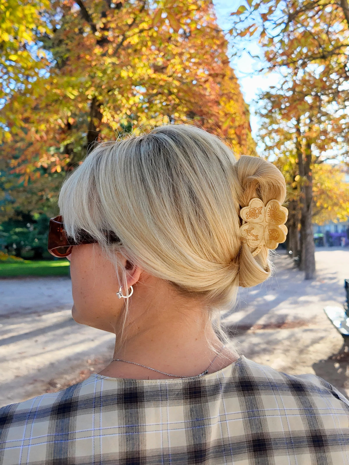 Clover claw clip in blonde hair, in an autumn park