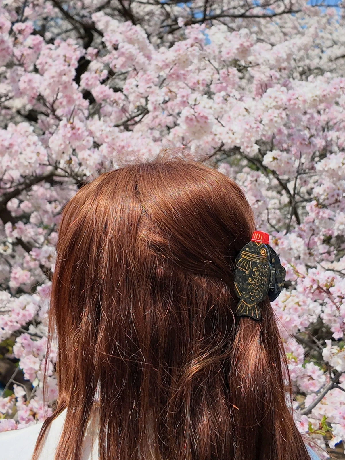 Mini soy sauce claw clip in auburn hair under cherry blossom
