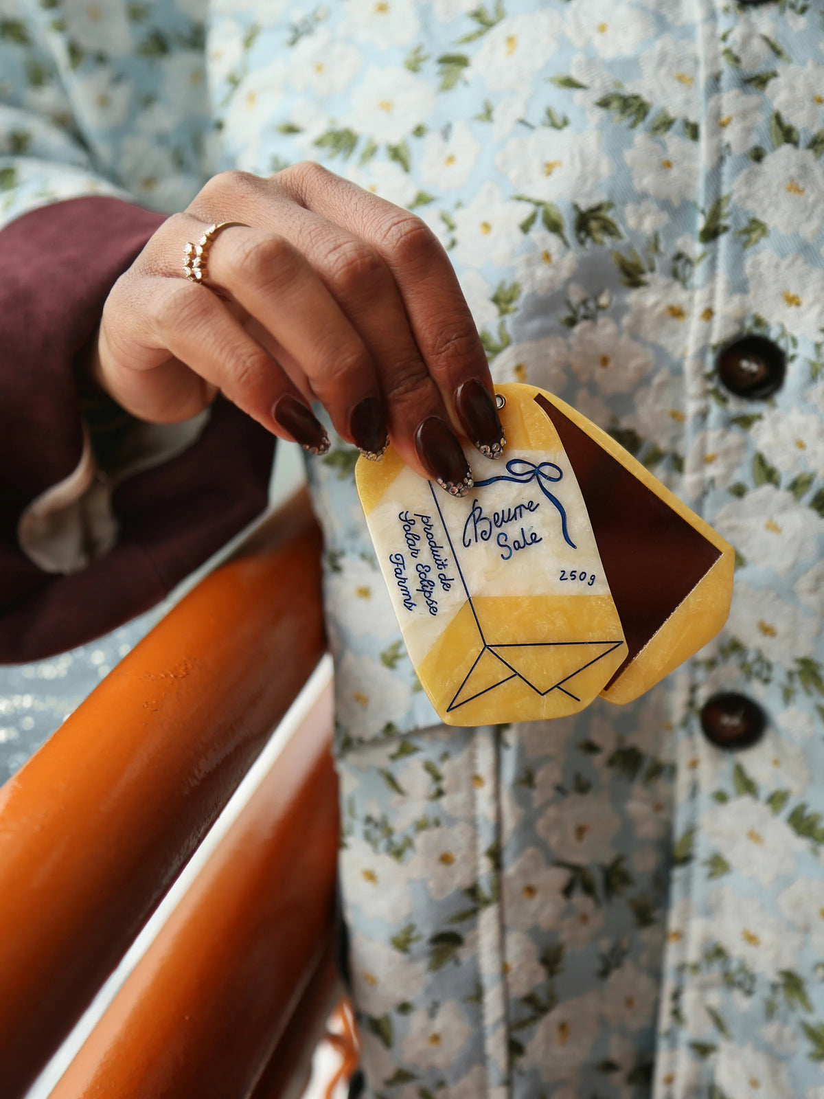 Hand pulling the French butter compact from a pocket