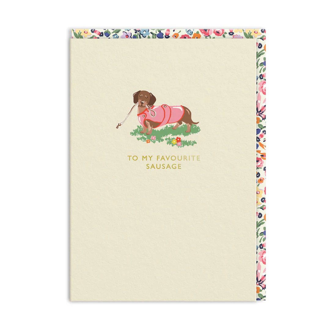 Cream card with a sausage dog in a pink jumper and a floral border: To my favourite sausage