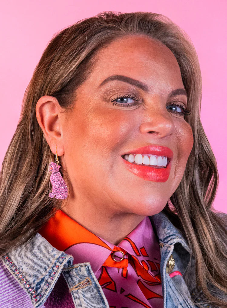 Smiling woman wearing the pink leopard earrings