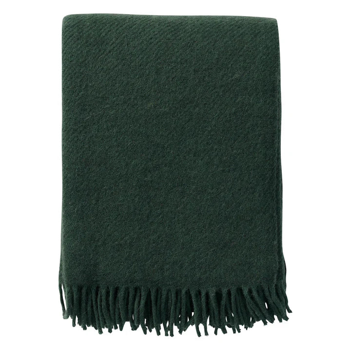 Klippan Gotland blanket in bottle green with fringed ends, folded