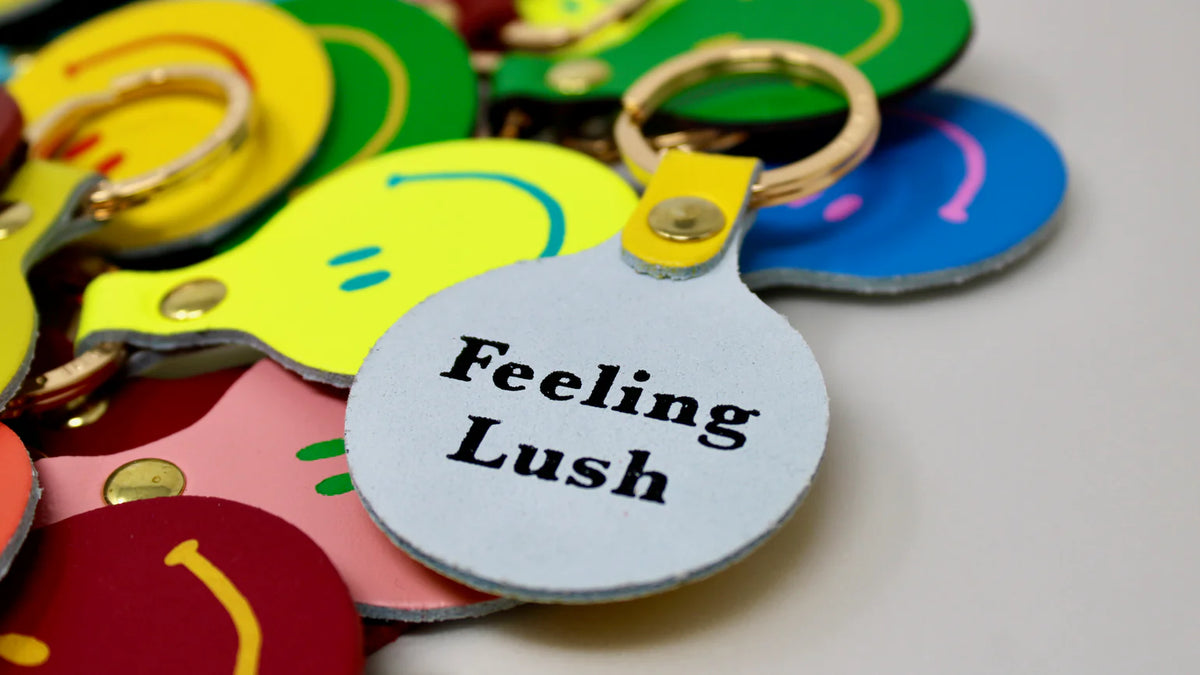 Ark smiley key fobs in many colours, one reading 'Feeling lush'