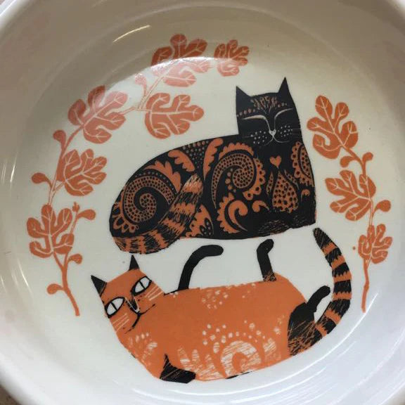 Cat bowl seen from above with the two patterned cats curled together