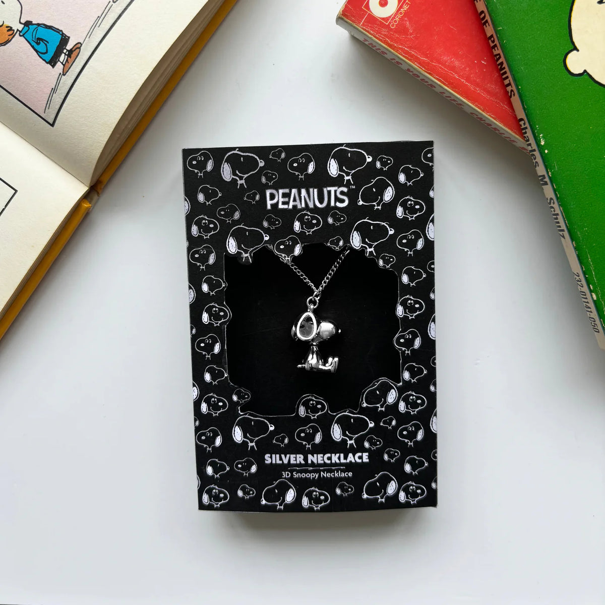 Peanuts silver necklace on its black Snoopy-print backing card