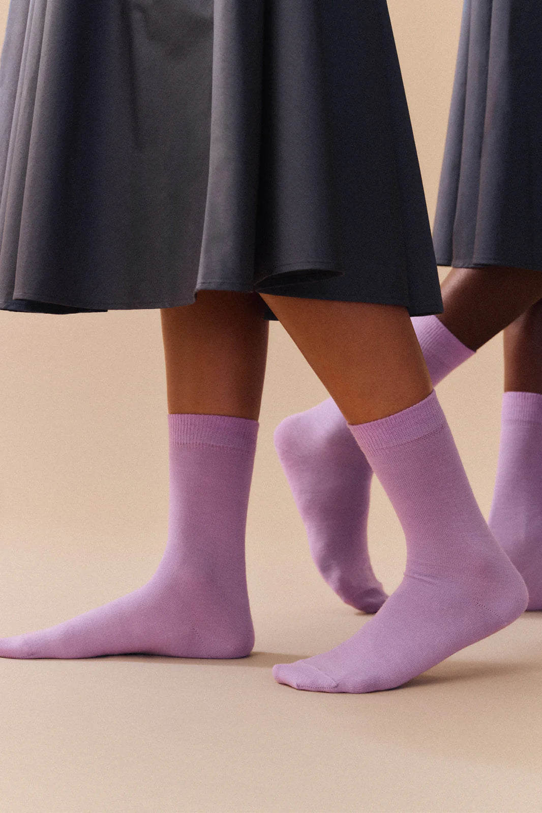 Person in a dark skirt wearing the palma violet socks