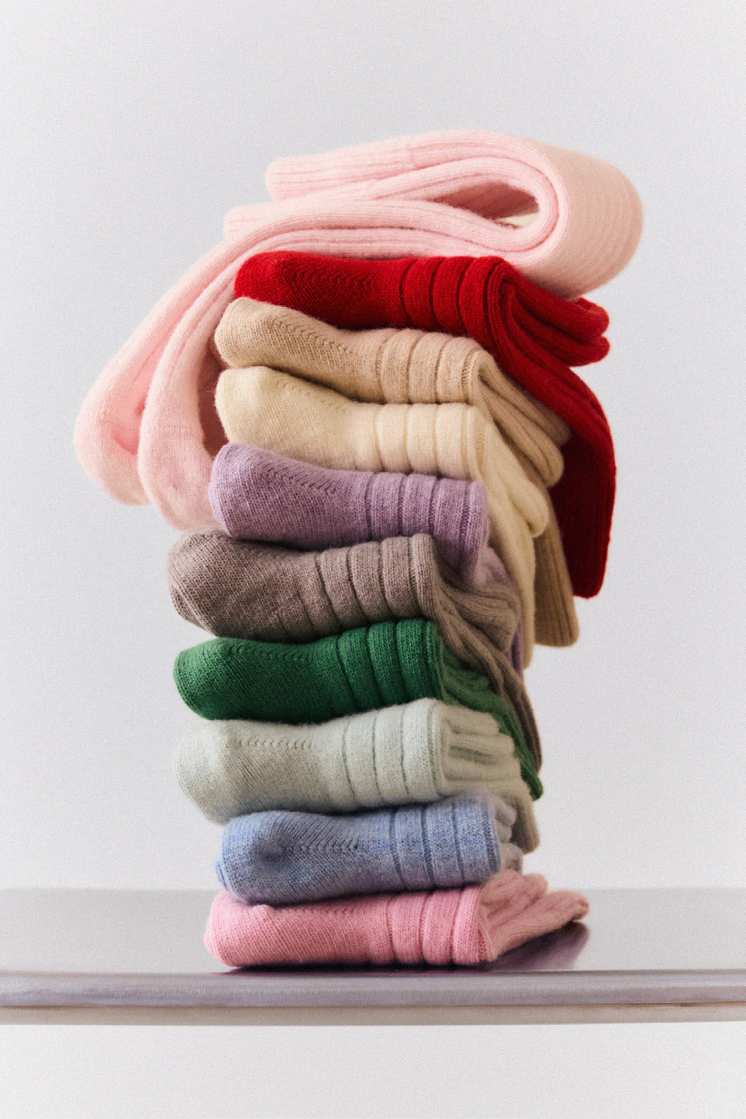 Stack of folded Pairs merino socks in many colours