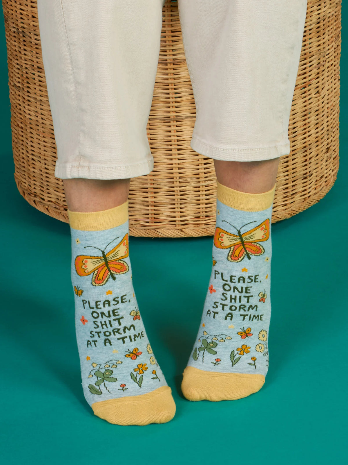 Person wearing the One Shit Storm socks with white trousers
