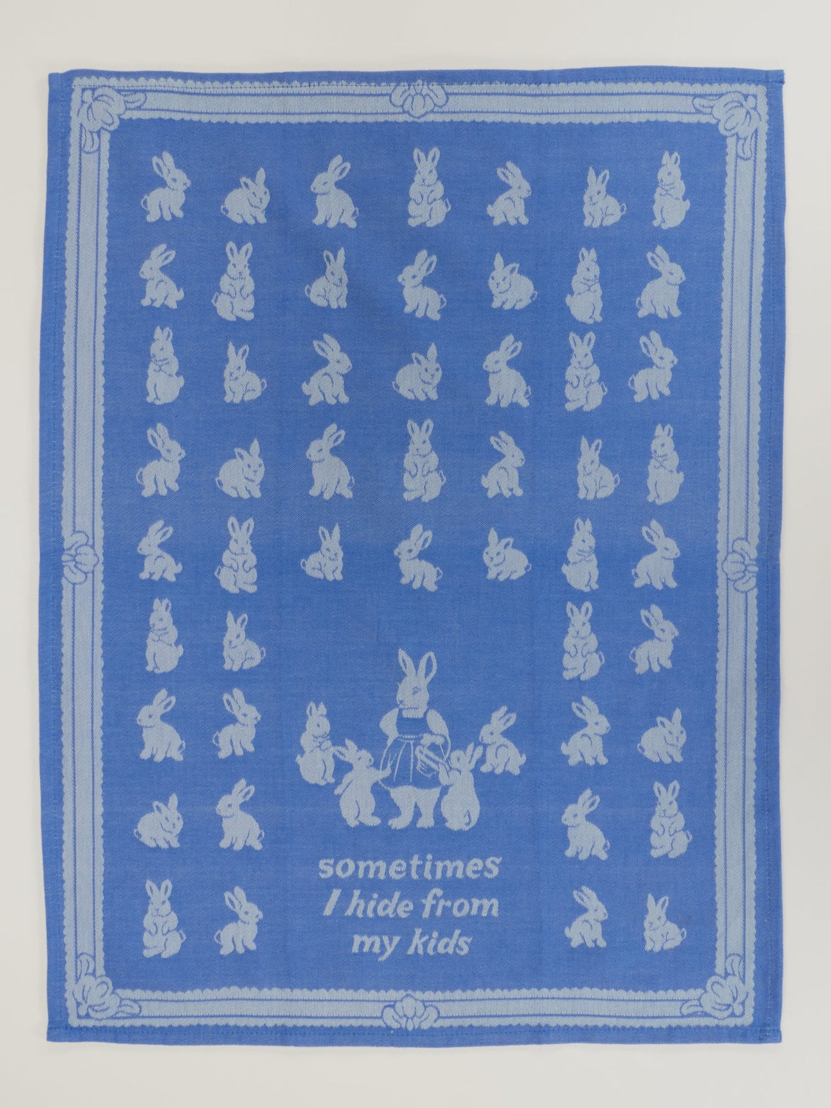 Unfolded tea towel with rows of rabbits and 'Sometimes I hide from my kids'