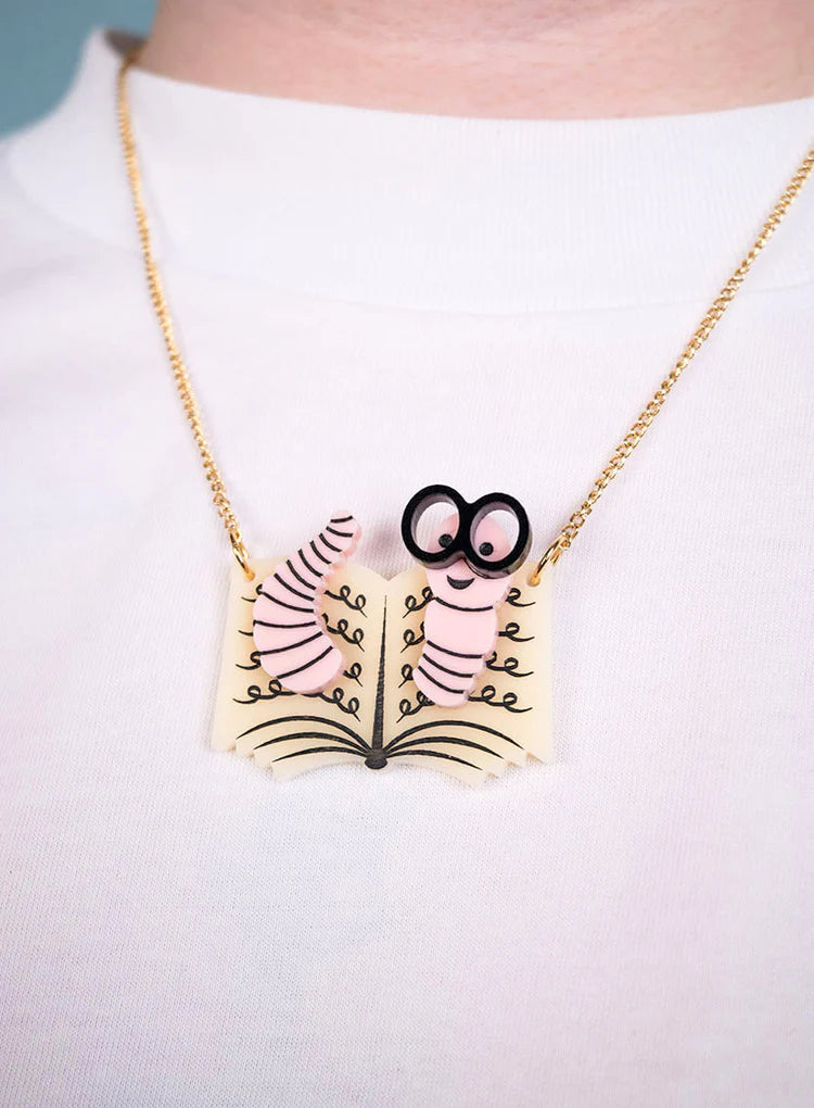 Bookworm necklace worn on a white top