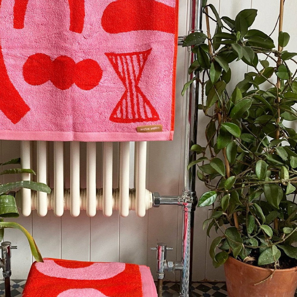 Pink and red abstract towels hanging on a radiator