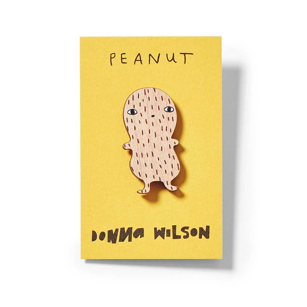 Peanut pin badge with a smiling face on a yellow Donna Wilson card: Peanut