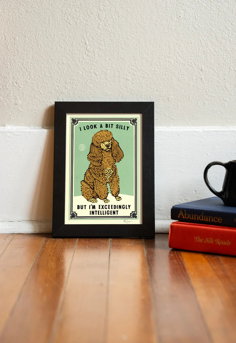 Exceedingly Intelligent print in a frame on a wooden floor