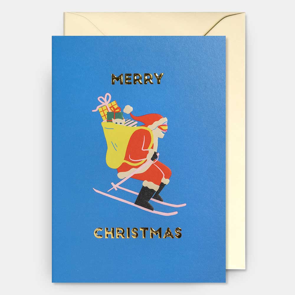 Blue card with Santa skiing with a sack of presents: Merry Christmas