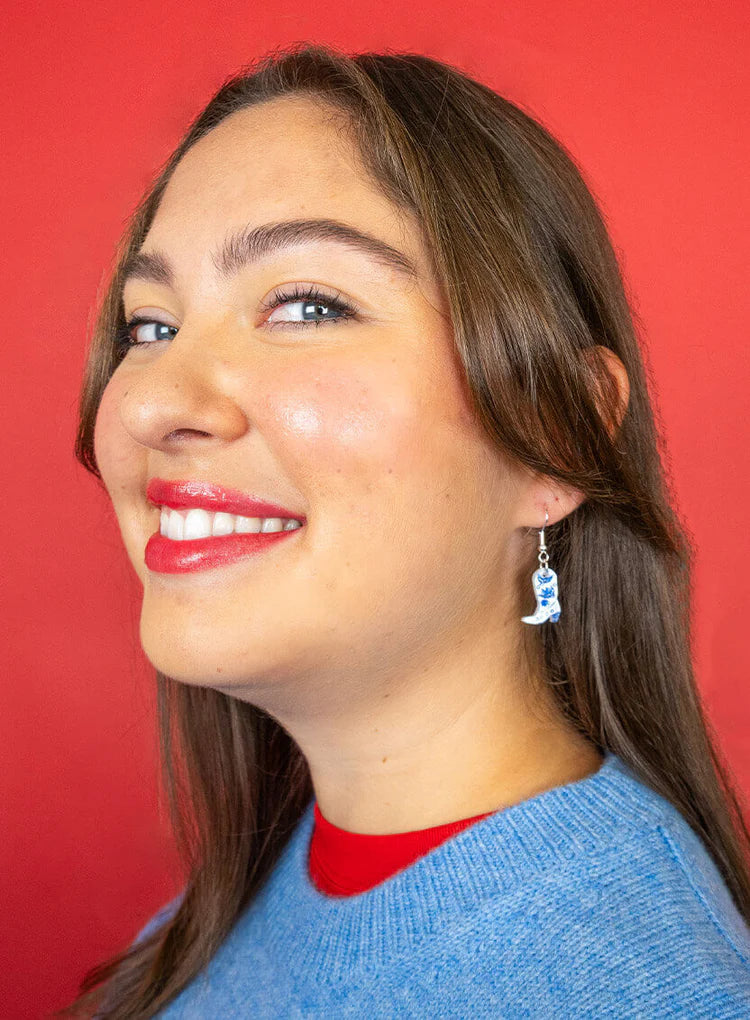 Smiling woman wearing the cowboy boot earrings