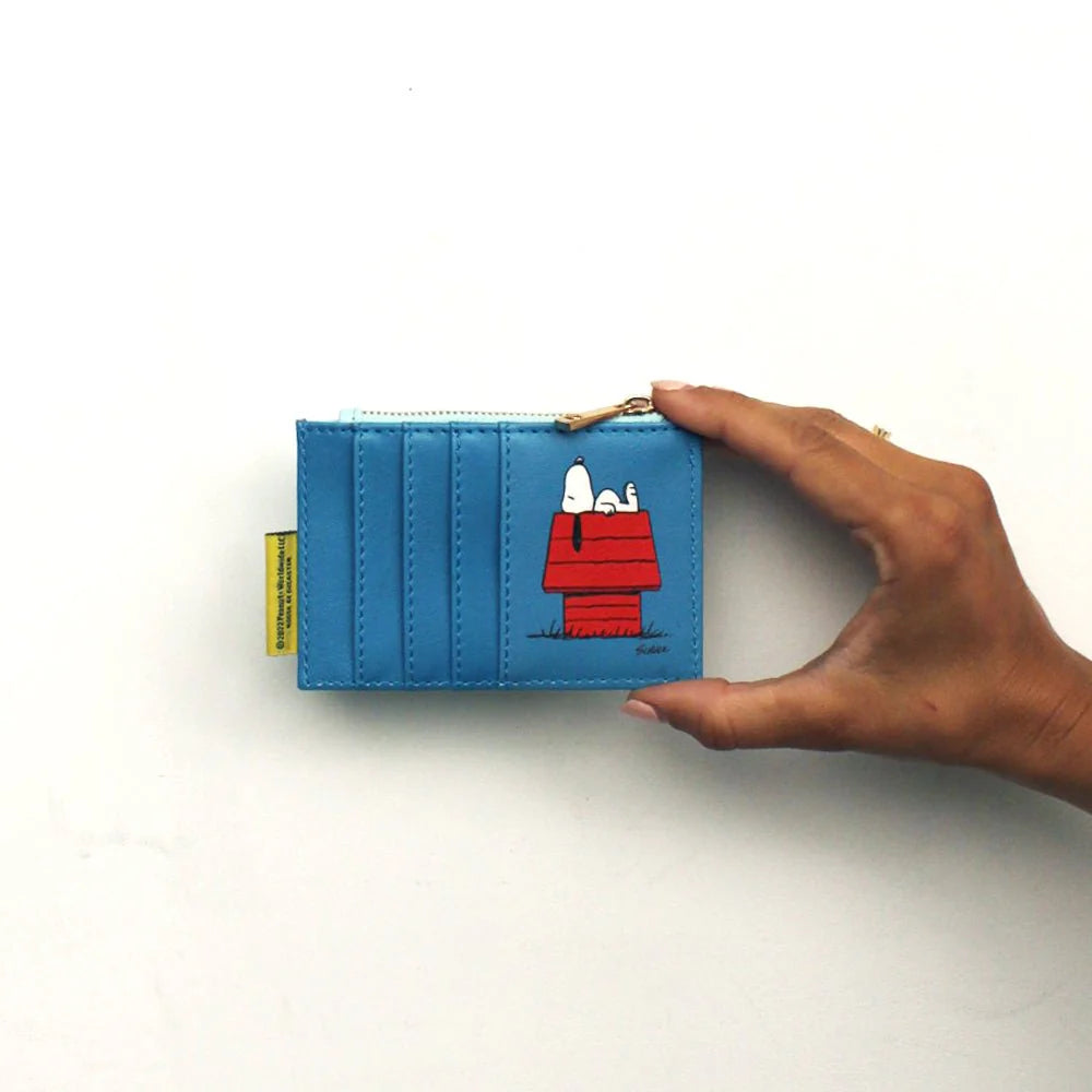 Hand holding the blue back of the Peanuts purse