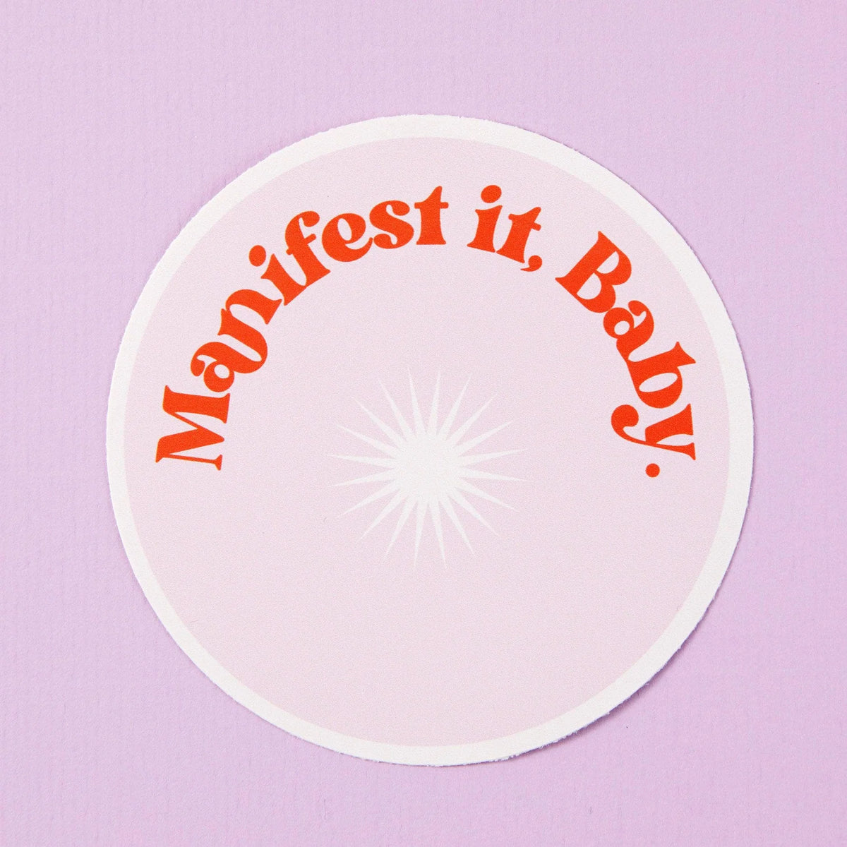 Round pink sticker: Manifest it, baby.