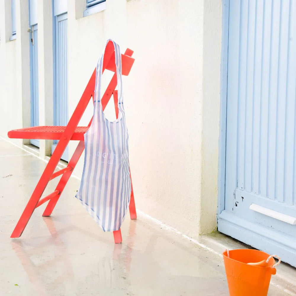 Striped swimsuit bag hanging on a red chair