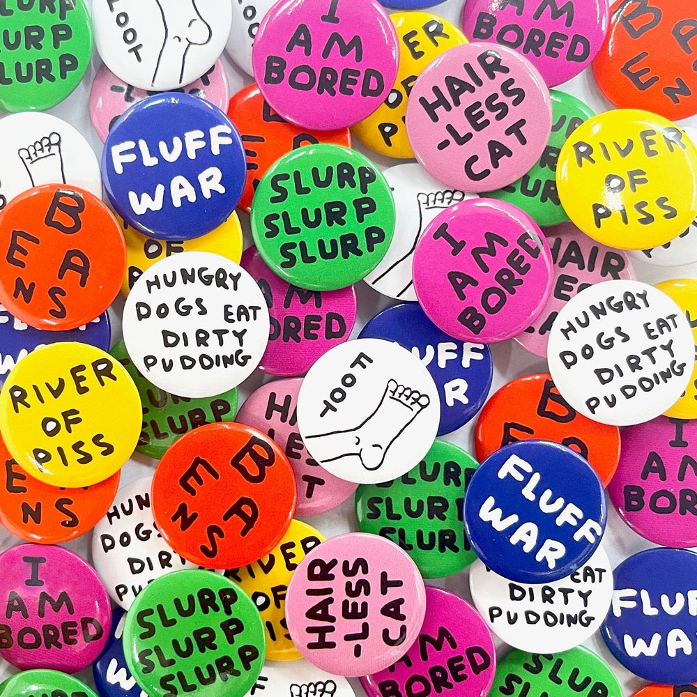 A pile of colourful David Shrigley badges