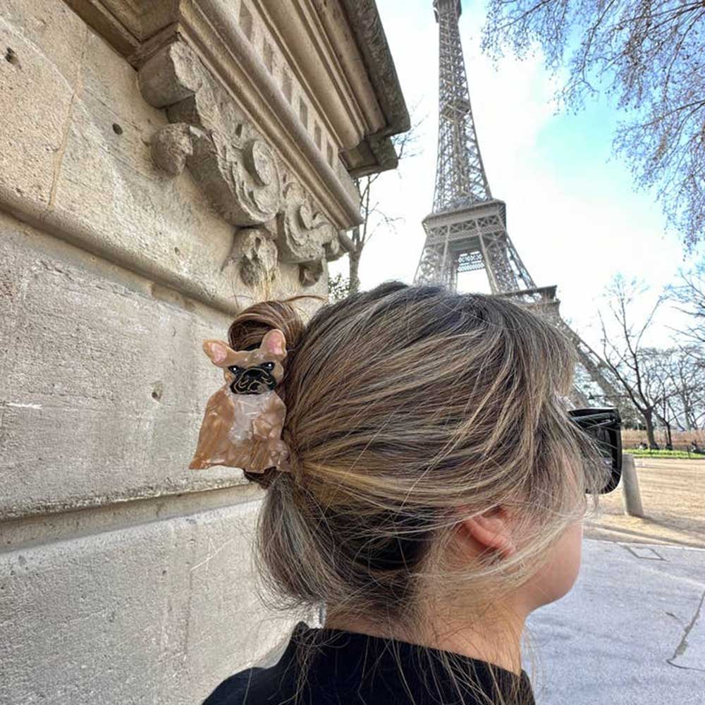 Frenchie claw clip in hair, with the Eiffel Tower behind