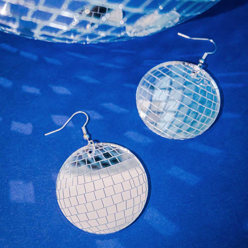 Disco ball earrings on blue under a disco ball