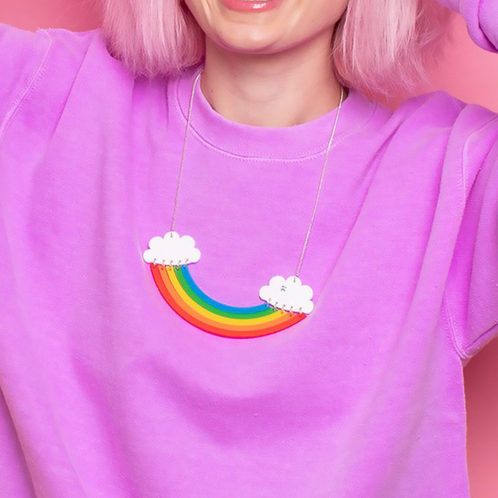 Woman in a pink top wearing the rainbow necklace
