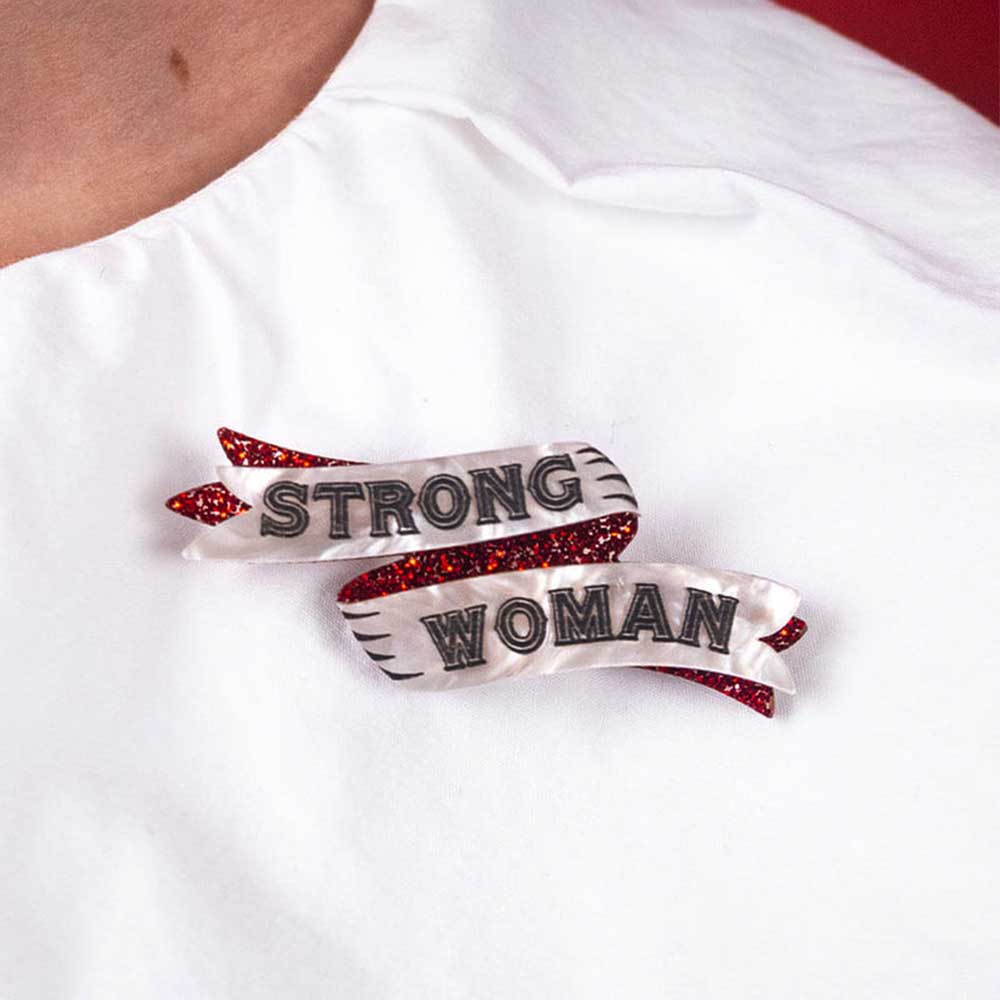 Strong Woman brooch worn on a white shirt