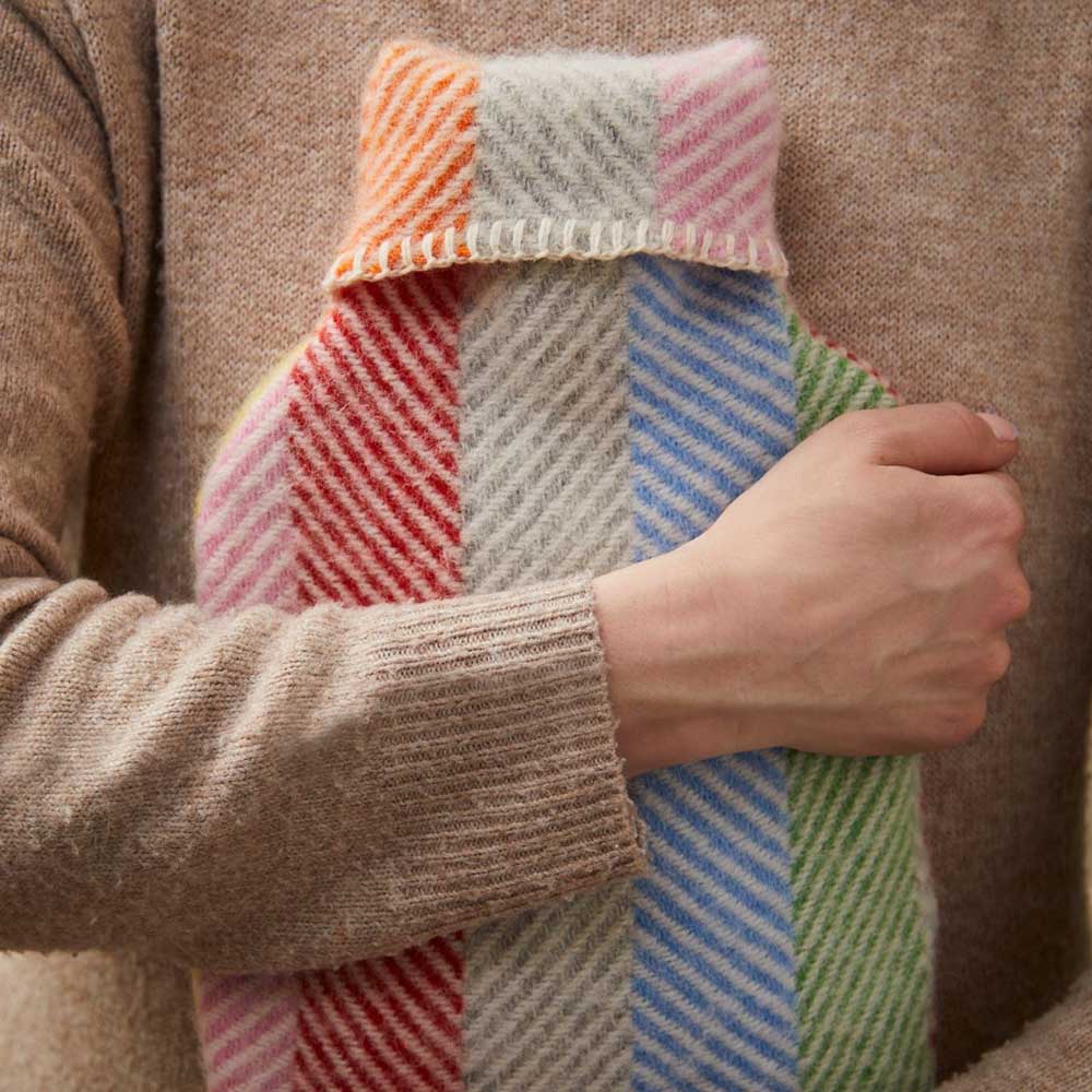 Person hugging the striped wool hot water bottle
