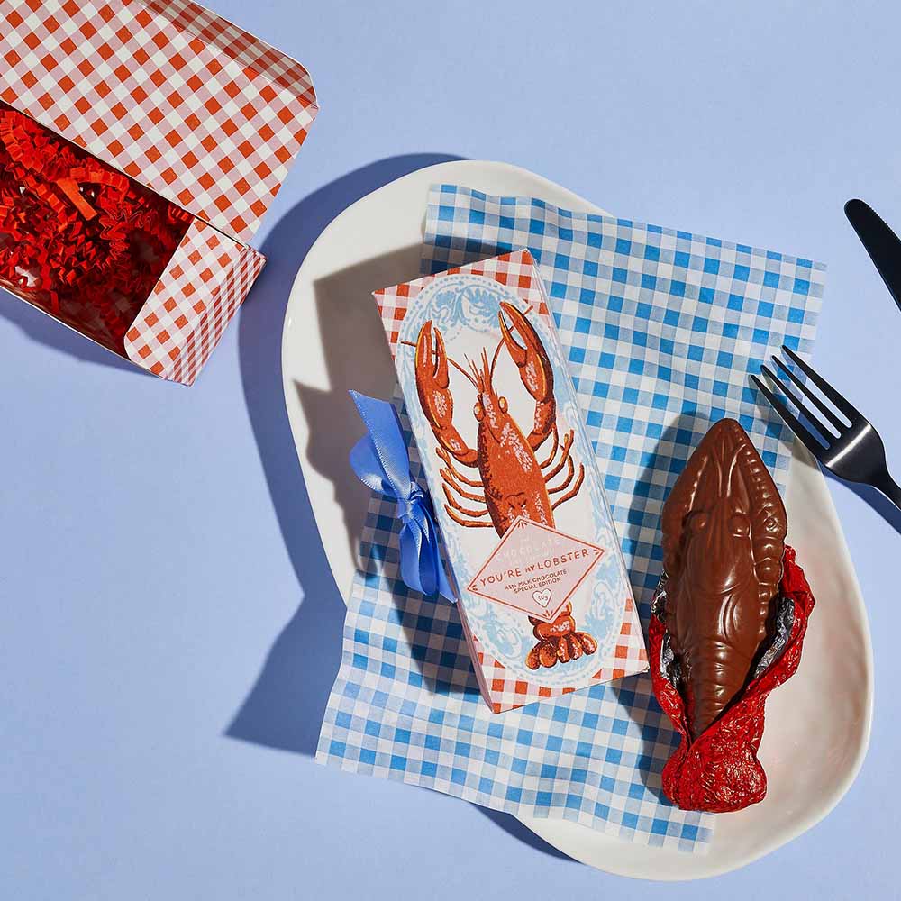 Chocolate lobster on a plate with a knife and fork
