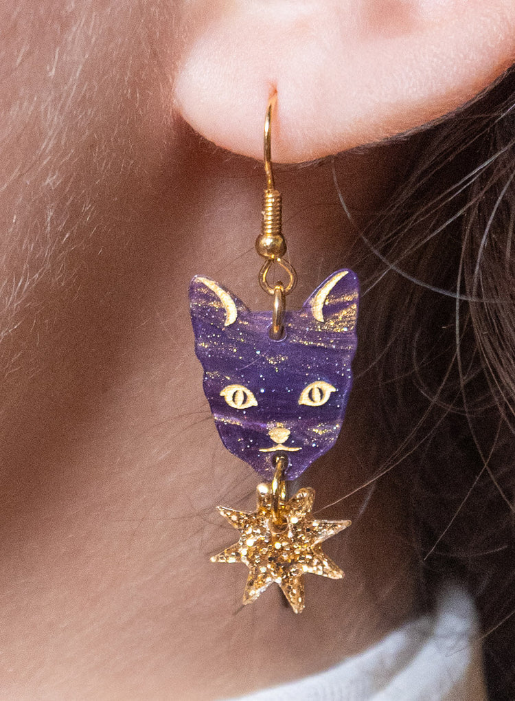 Astrologer's Cat earring with a gold star, worn