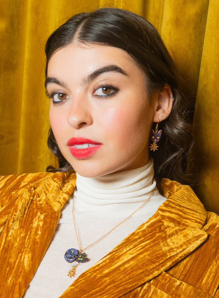 Woman in a gold velvet jacket wearing the Astrologer's Cat necklace