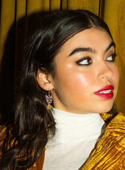 Woman in a gold velvet jacket wearing the Astrologer's Cat earrings