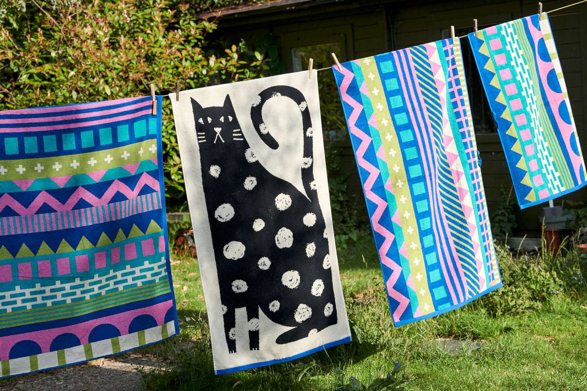 Donna Wilson towels including a black cat towel drying on a washing line
