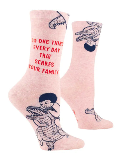 Blue Q pink socks reading 'Do one thing every day that scares your family', with a figure riding a crocodile