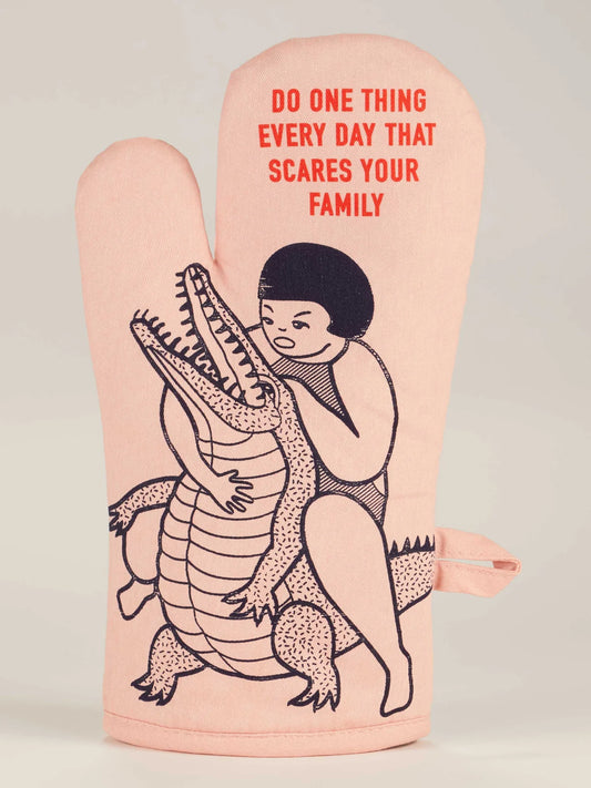 Blue Q oven mitt: a figure hugging a crocodile, with 'Do one thing every day that scares your family'