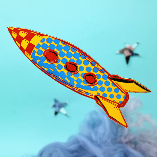 Ark rocket bookmark in yellow and blue with red portholes, flying above clouds