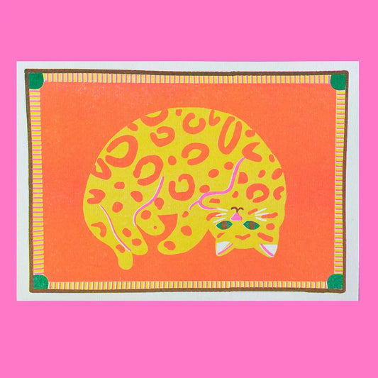 Naomi Wilkinson A5 mini print: a curled-up yellow leopard-spotted cat on orange