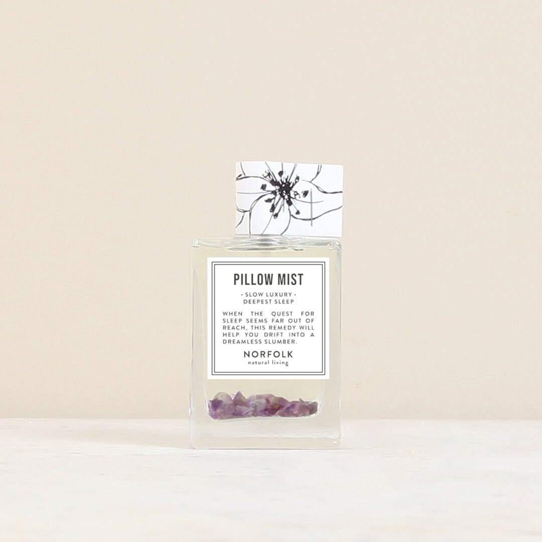 Norfolk Natural Living pillow mist: a clear glass spray bottle with purple crystals inside, beside its floral box