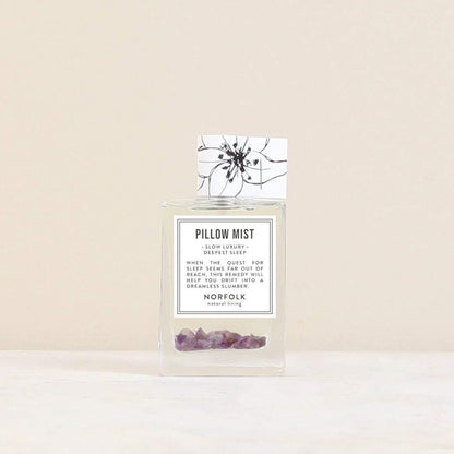 Norfolk Natural Living pillow mist: a clear glass spray bottle with purple crystals inside, beside its floral box