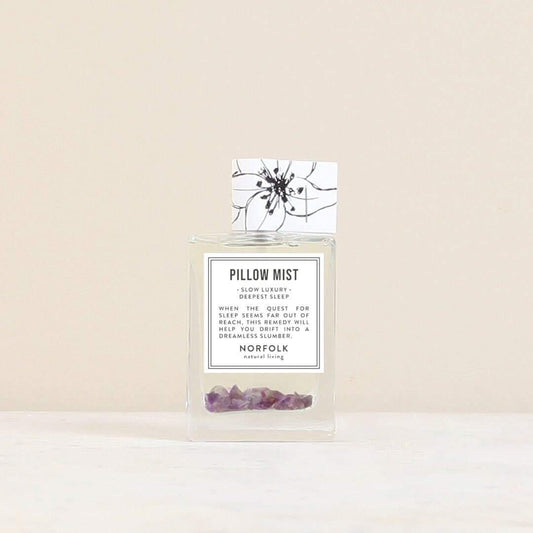 Norfolk Natural Living pillow mist: a clear glass spray bottle with purple crystals inside, beside its floral box